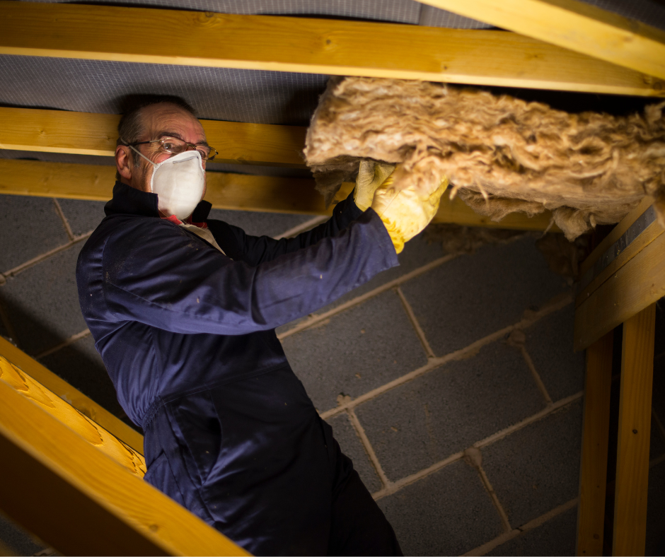 Man installing loft insulation.