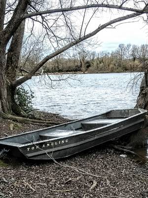 An abandoned boat by a lake
