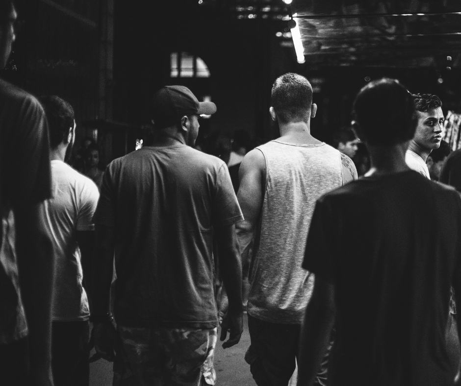 Black and white image of youths with backs to the camera