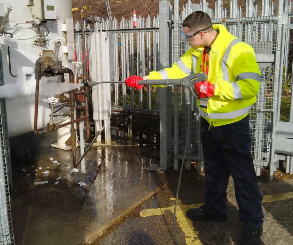 Ben using a jet washer while working for Mitie.