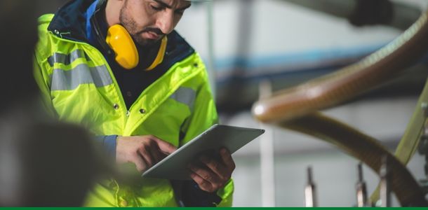 Person in a high-viz jacket checking an ipad