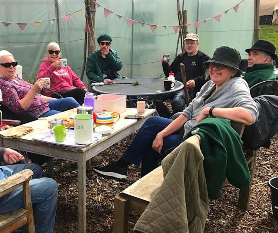 The Communigrow team sitting round a table having a cup of tea.