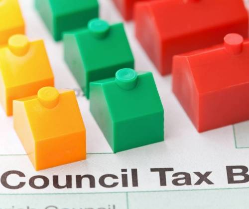 A council tax bill with plastic houses on top.