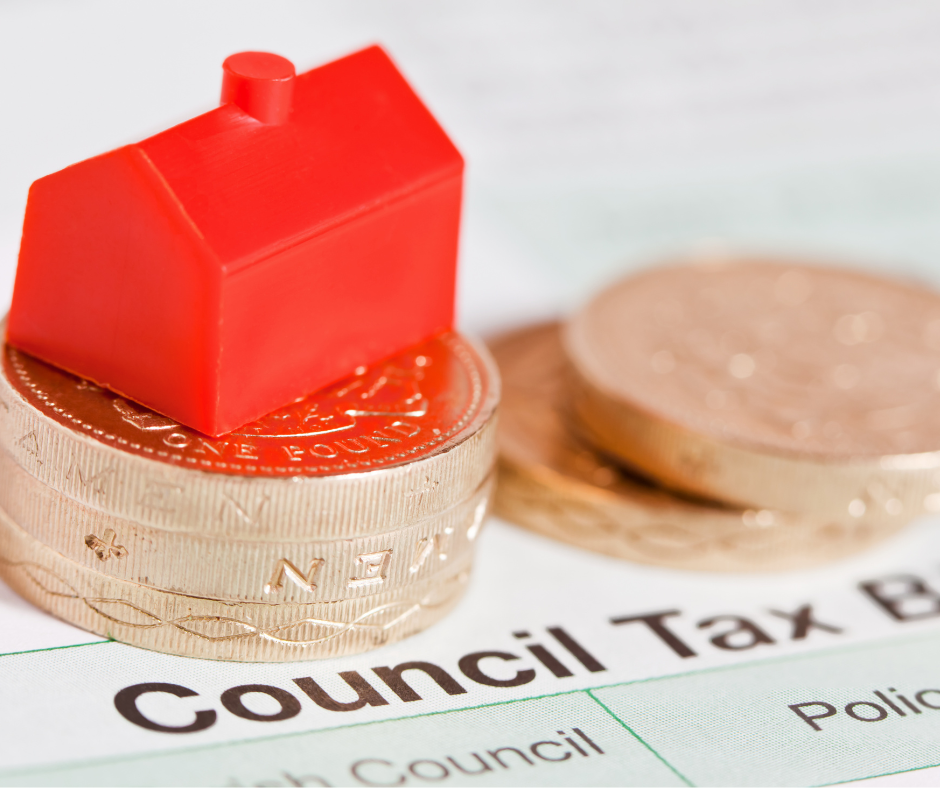 A red plastic house on top of pound coins with a council tax bill.