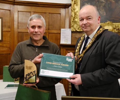 Two men, the Mayor and award recipient stand side by side with a certificate and the award.