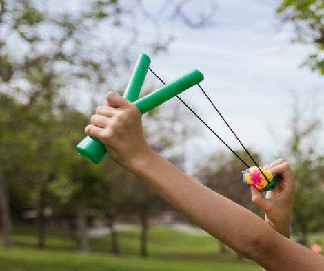 A close-up image of hands firing a catapult in a park