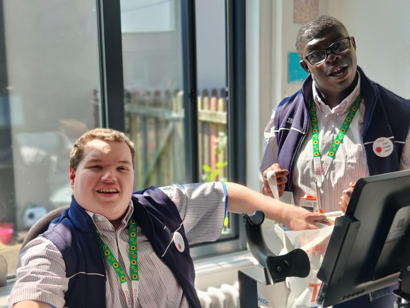 A photo of two young people at a Tesco till