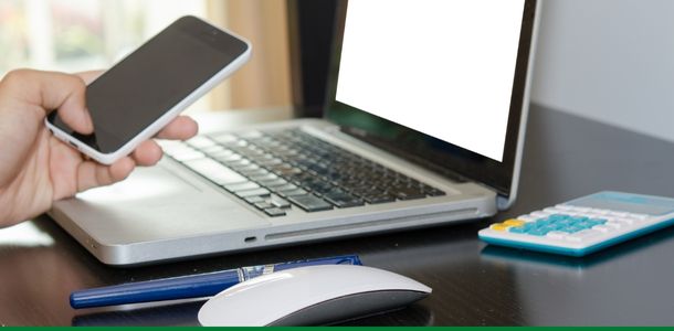 A person using a phone and laptop