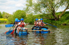 2 teams of children on homemade rafts on a river