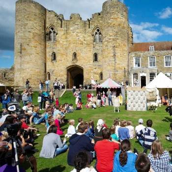 A crowd on the castle lawn in the sunshine